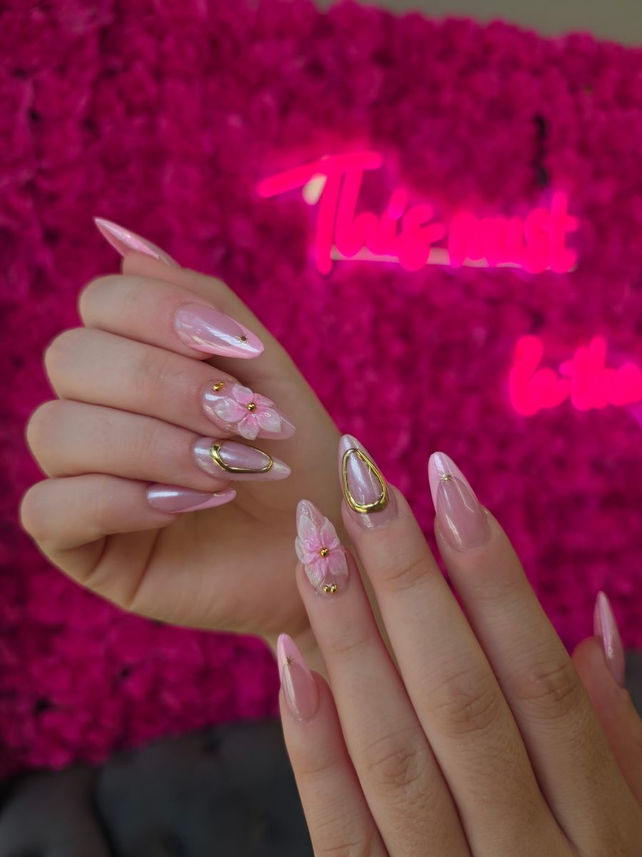 Pearl-pink chrome with pink 3D flowers and gold bezels nails at Modish Nail Lounge Rancho Cucamonga