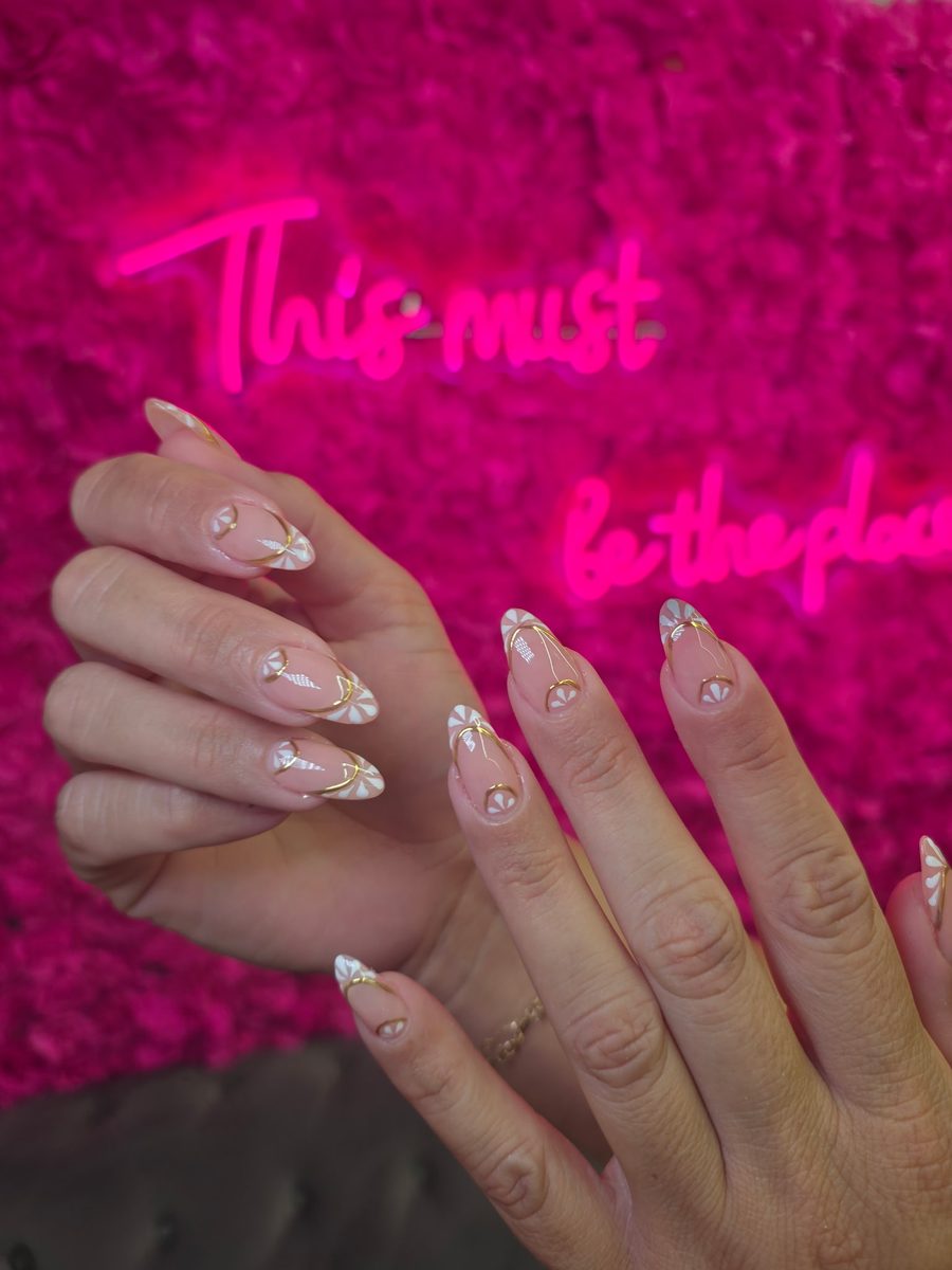 Nude almonds with delicate white floral and gold linework nails at Modish Nail Lounge Rancho Cucamonga