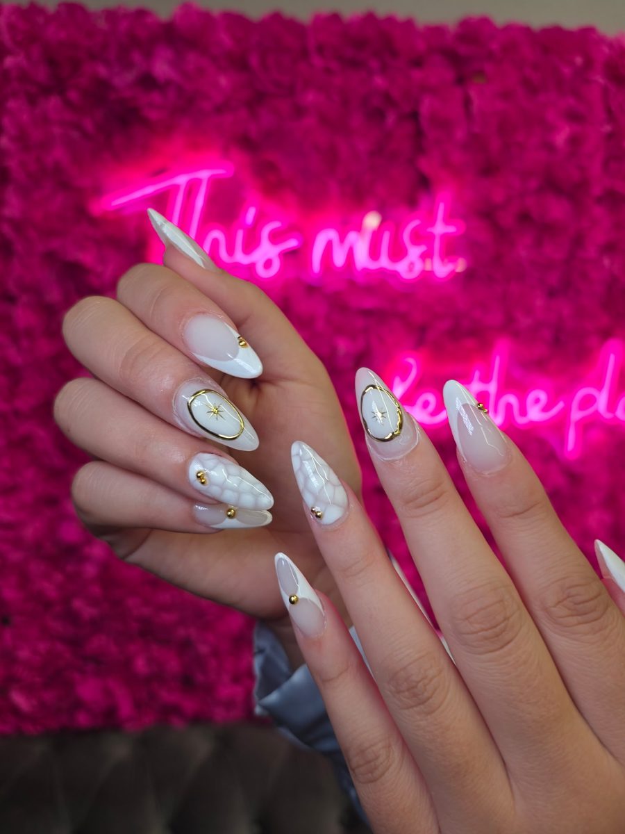 White & cream with gold compass-star charms nails at Modish Nail Lounge Rancho Cucamonga