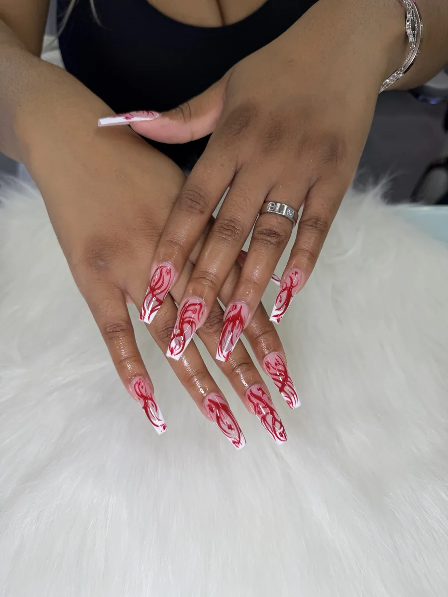 Sheer nude coffin with red swirl art and white tips nails at Modish Nail Lounge Rancho Cucamonga
