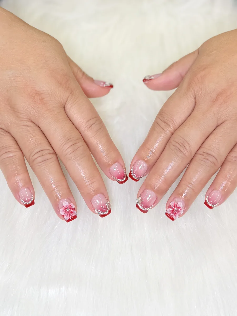 Red French with rhinestones on short almonds nails at Modish Nail Lounge Rancho Cucamonga